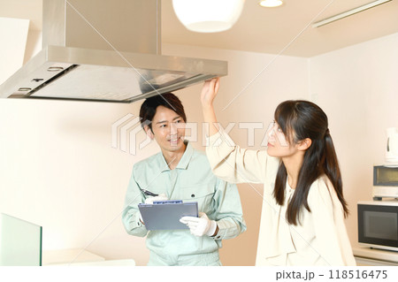 レンジフードを確認する男性作業員と女性客 118516475