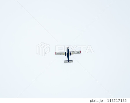 Small ultralight airplane with overhead wing and single propeller flying in sunset sky. 118517183