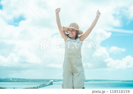 宮古島絶景ポイントから見た伊良部大橋と麦わら帽子の女性 118518159