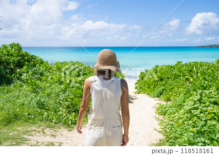 美しいビーチと麦わら帽子の若い女性 118518161
