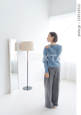 鏡を見て身だしなみをチェックする女性 118518522