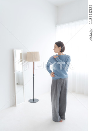 鏡を見て身だしなみをチェックする女性 鏡を見て身だしなみをチェックする女性 118518523