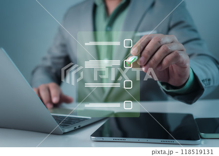 Businessman working on laptop and tablet productivity checklist and filling survey form online. Document management system DMS. Assessment form, questionnaire, Checklist and clipboard task management. 118519131