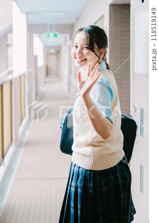玄関で見送る家族に手を振る制服の女子高生 118519149