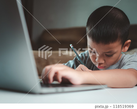 Technology studying at home using laptop computer, Student distance learning virtual distance online class on video call virtual lesson, Parent or tutor teaching child boy with remote education. Technology studying at home using laptop computer, Student distance learning virtual distance online class on video call virtual lesson, Parent or tutor teaching child boy with remote education. 118519369