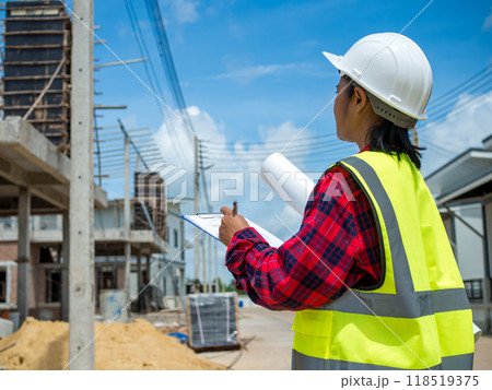 Engineers holding blueprint project working outdoors building side with blueprints on a worksite, Engineering and architecture concept, Engineer working at site of a large building project. 118519375