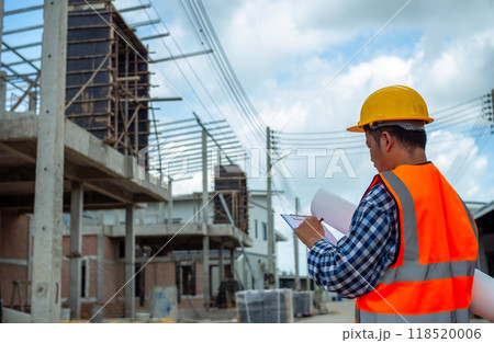 Engineers holding blueprint project working outdoors building side with blueprints on a worksite, Engineering and architecture concept, Engineer working at site of a large building project. Engineers holding blueprint project working outdoors building side with blueprints on a worksite, Engineering and architecture concept, Engineer working at site of a large building project. 118520006