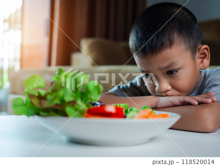 Little cute boy refuses to eat healthy vegetables, Children do not like to eat vegetables, Nutrition healthy eating habits for kids concept, Children do not like to eat vegetables. Little cute boy refuses to eat healthy vegetables, Children do not like to eat vegetables, Nutrition healthy eating habits for kids concept, Children do not like to eat vegetables. 118520014