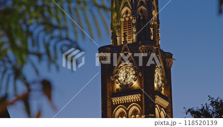 Close-up view on Rajabai Clock Tower In Evening Illumination. Clock Tower In Mumbai India. Confines Of Fort Campus Of University Of Mumbai. It Stands At Height Of 85 M or 280 Ft. Modeled It On Big Ben 118520139