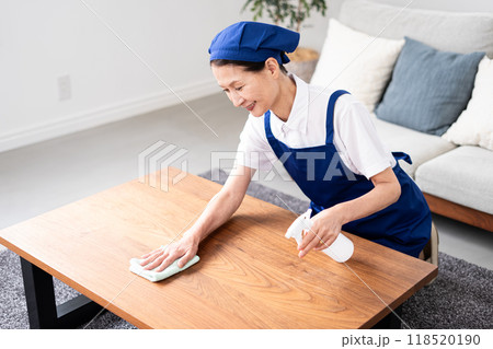 青色のエプロンを付けた白いポロシャツのシニア女性のハウスキーパー 青色のエプロンを付けた白いポロシャツのシニア女性のハウスキーパー 118520190