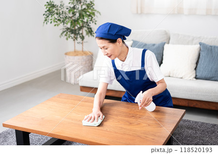 青色のエプロンを付けた白いポロシャツのシニア女性のハウスキーパー 青色のエプロンを付けた白いポロシャツのシニア女性のハウスキーパー 118520193