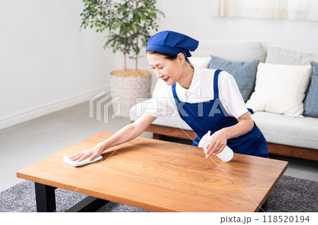 青色のエプロンを付けた白いポロシャツのシニア女性のハウスキーパー 青色のエプロンを付けた白いポロシャツのシニア女性のハウスキーパー 118520194