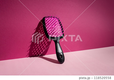 Vertical hairbrush leaning against wall, casting shadow under bright sunlight 118520558