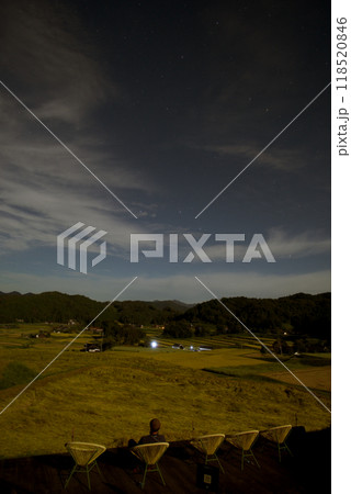 月明かり　三河内棚田テラス　月に照らされた椅子に座る人、黄金色の棚田、星空　コピースペース 118520846