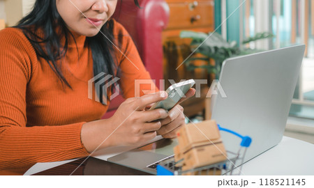 Asia women working business SME online at home her checking order from smartphone  for customer and online delivery for ready packing, Checking orders from customers with digital laptop. 118521145