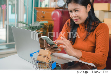 Asia women working business SME online at home her checking order from smartphone for customer and online delivery for ready packing, Checking orders from customers with digital laptop. Asia women working business SME online at home her checking order from smartphone for customer and online delivery for ready packing, Checking orders from customers with digital laptop. 118521146