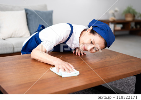 青色のエプロンを付けた白いポロシャツのシニア女性のハウスキーパー 青色のエプロンを付けた白いポロシャツのシニア女性のハウスキーパー 118522171