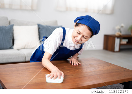 青色のエプロンを付けた白いポロシャツのシニア女性のハウスキーパー 118522173