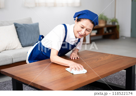 青色のエプロンを付けた白いポロシャツのシニア女性のハウスキーパー 118522174