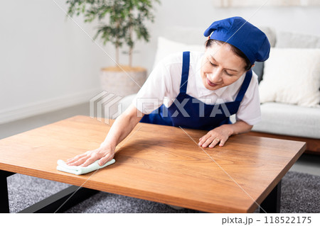 青色のエプロンを付けた白いポロシャツのシニア女性のハウスキーパー 118522175