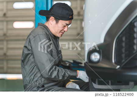 リフトアップした車のタイヤを脱着する整備士の男性 118522400