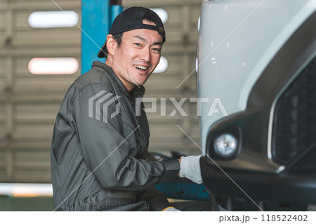 リフトアップした車のタイヤを脱着する整備士の男性 リフトアップした車のタイヤを脱着する整備士の男性 118522402