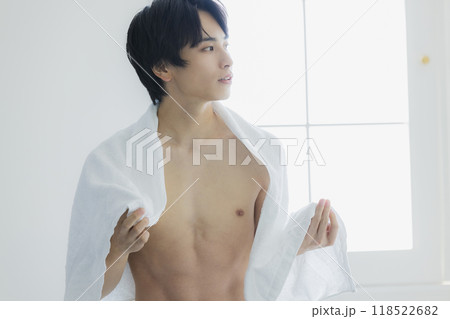 裸で体をバスタオルで拭く若い男性 118522682