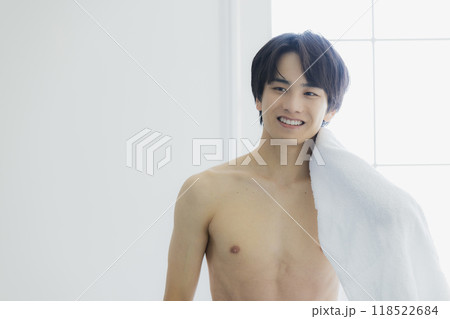 裸で体をバスタオルで拭く若い男性 118522684
