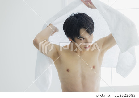 裸で体をバスタオルで拭く若い男性 118522685
