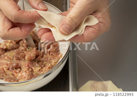 ワンタン　ワンタンの皮で肉だねを包む手元 118522993