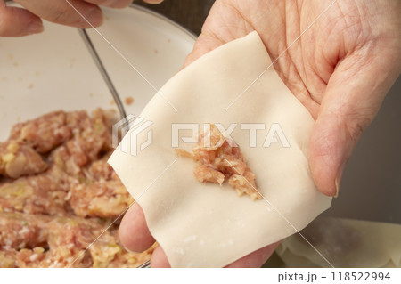 ワンタン　ワンタンの皮で肉だねを包む手元 118522994