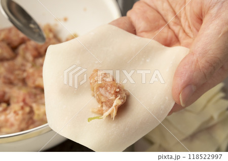 ワンタン　ワンタンの皮で肉だねを包む手元 118522997