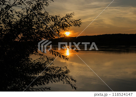 The sun is slowly setting over a beautiful body of water 118524147