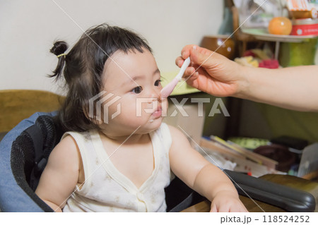 【離乳食を食べる髪を結んだ赤ちゃん】 【離乳食を食べる髪を結んだ赤ちゃん】 118524252