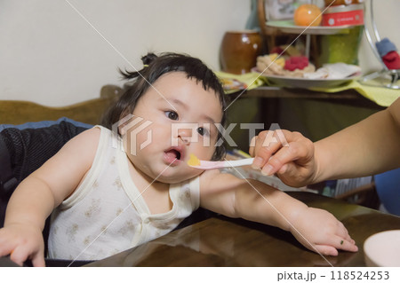 【離乳食を食べる髪を結んだ赤ちゃん】 【離乳食を食べる髪を結んだ赤ちゃん】 118524253