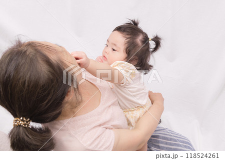 【おばあちゃんの顔を触る赤ちゃん】 118524261
