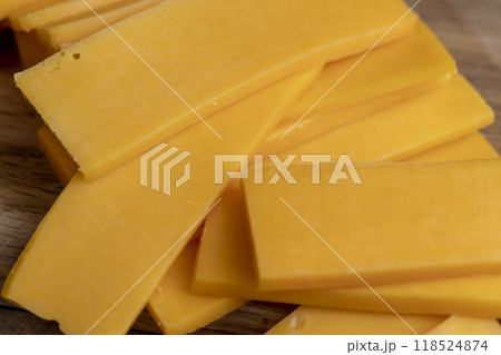 slicing yellow cheese close-up 118524874