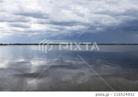 lake and trees on the shore before a storm lake and trees on the shore before a storm 118524932