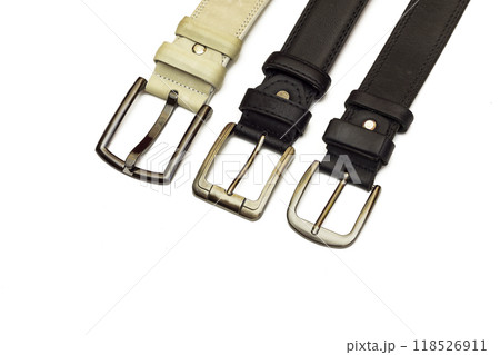 Three leather belts of different sizes lie on a white background 118526911