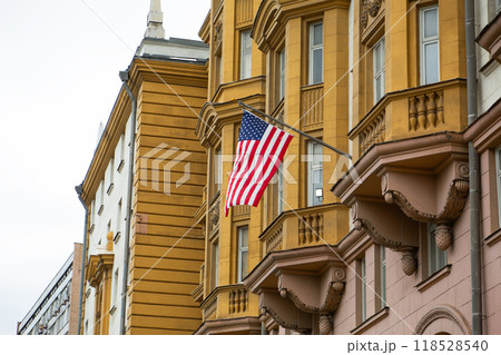 Photography of American flag flying on top of the country embassy. American culture and the symbol of states on facade of building 118528540