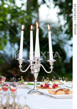 Catering buffet table with snacks and appetizers and candles 118529116