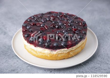 Tyrolean pie with soft custard, cherries and blueberries. Biscuit pie with light cream, with fresh berries and jelly. Traditional baking. Close-up, selective focus. 118529590