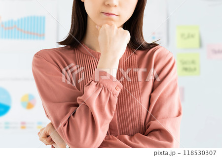 ホワイトボードの前で考えごとをする若いビジネスウーマン ホワイトボードの前で考えごとをする若いビジネスウーマン 118530307