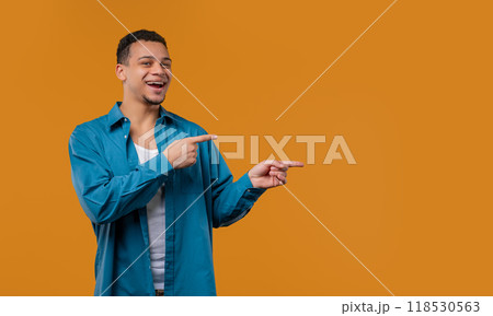 Stylish smiling multiracial man pointing right side, copy space or advertising. 118530563