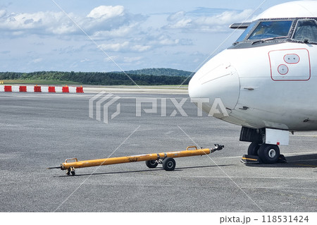 Close-up of aircraft towbar next to small airplane wheel in preparation for pushback before departture Close-up of aircraft towbar next to small airplane wheel in preparation for pushback before departture 118531424