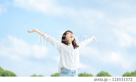 青空に両手を広げる笑顔の女性 118531572
