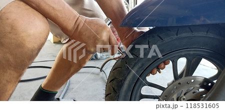 Technician patching a tire motorcycle tires 118531605