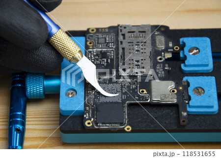 Technician is repairing Smartphone motherboard, circuit repair Technician is repairing Smartphone motherboard, circuit repair 118531655