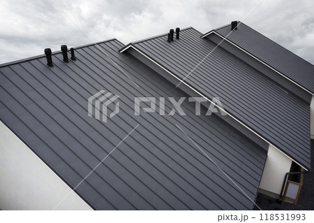 Close-up house retro roof panel with standing seam and fasteners. Modern galvanized steel roofing sheet with ribs. Classic style black metal panel with rebate joint. Falz roofing. Building's covering 118531993