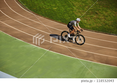 Man bicyclist enjoying training cycling on open velodrome track view from afar 118532043